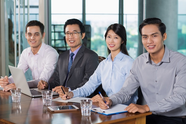 Sonriendo gente de negocios que tienen reunión en la oficina