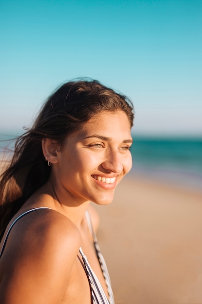 Foto gratuita sonriendo hermosa mujer en la playa de arena