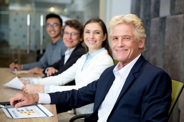 Sonriendo líder de alto rango en la reunión con su equipo