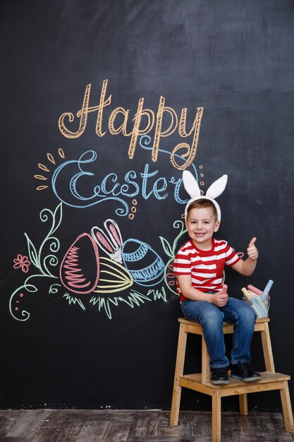 Sonriendo lindo niño pequeño con orejas de conejo de Pascua