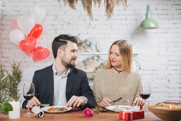 Sonriendo mujer y hombre disfrutando de la cena