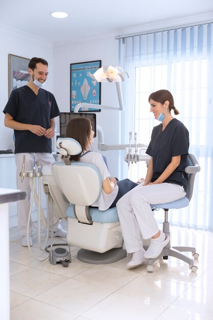 Sonriendo paciente y dentista en clínica dental