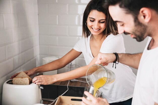 Sonriendo par cocinar el desayuno juntos