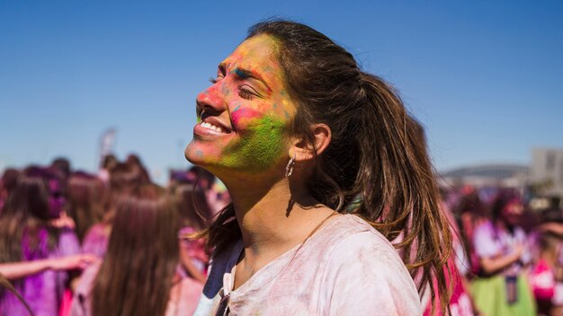 Sonriendo el rostro de una joven pintada con holi color.
