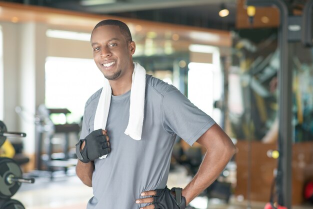 Sonriendo la toalla que lleva deportiva del hombre negro alrededor del cuello