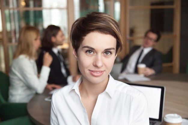 Foto gratuita sonriendo trabajadora posando para el catálogo de negocios de la empresa