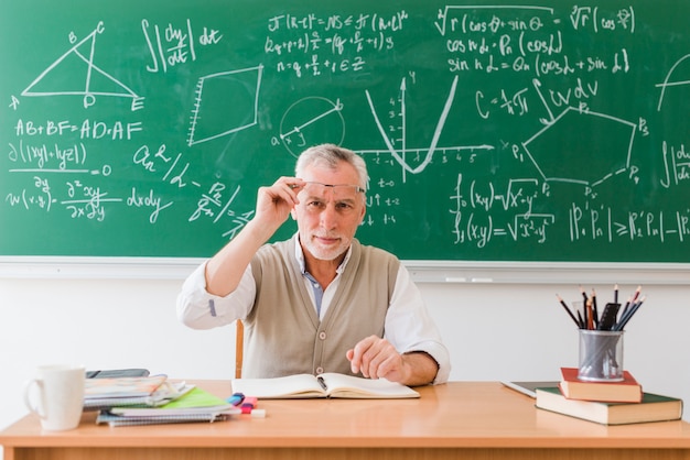 Sonriendo viejo profesor de matemáticas en el aula