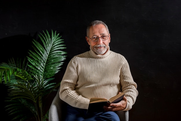 Sonriente anciano con libro