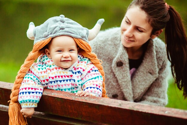 Sonriente bebé y la madre sentada en el banco