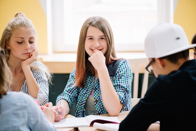 Sonriente colegiala con compañeros de clase