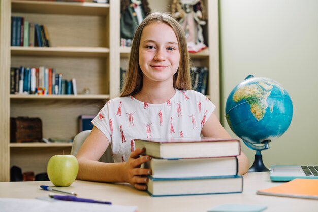 Sonriente colegiala con libros