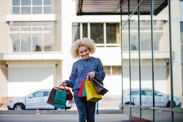 Foto gratuita sonriente comprador caminando en la ciudad