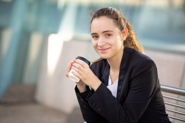 Sonriente exitosa mujer gerente disfrutando de un café