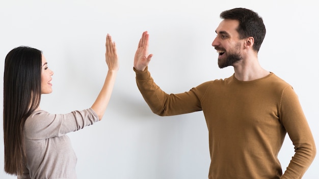 Sonriente hombre adulto y mujer listos para chocar los cinco