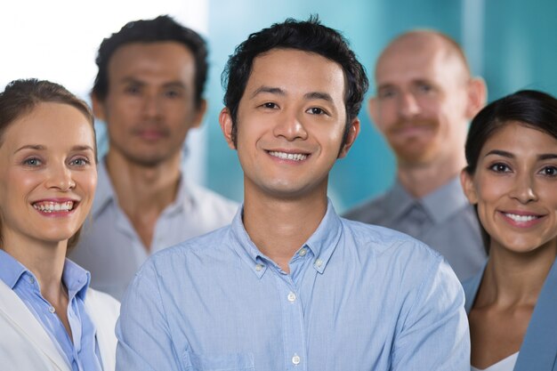 Sonriente hombre asiático trabajando con profesionales