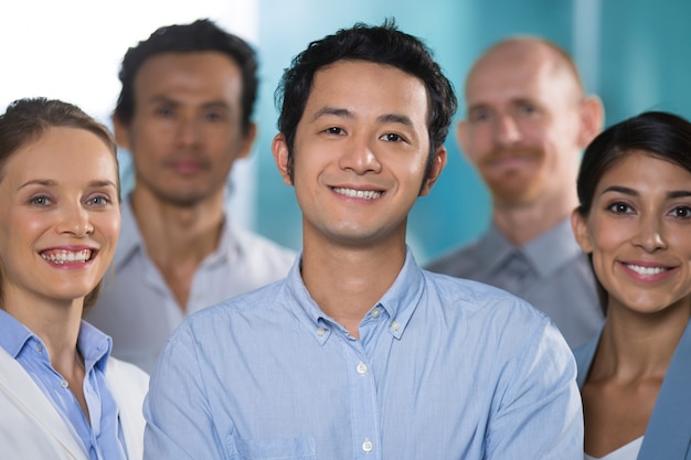 Sonriente hombre asiático trabajando con profesionales