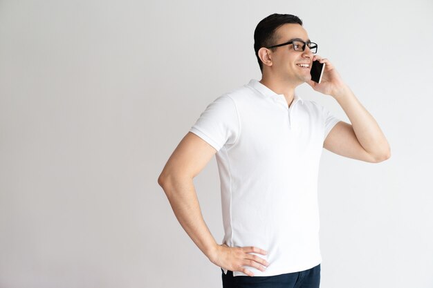 Sonriente hombre guapo hablando por teléfono inteligente. Joven llamando por teléfono celular.