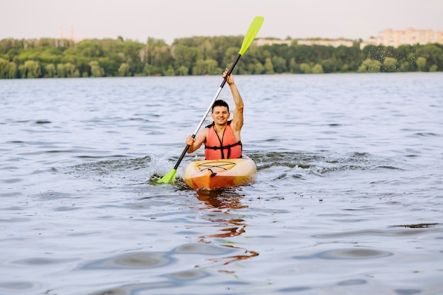 Sonriente hombre kayak en el lago
