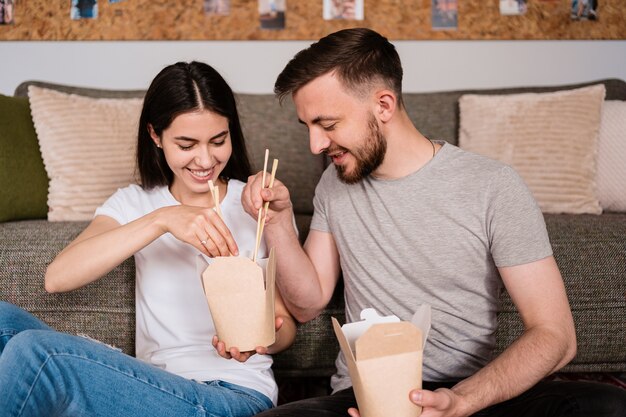 Sonriente hombre y mujer almorzando juntos en casa