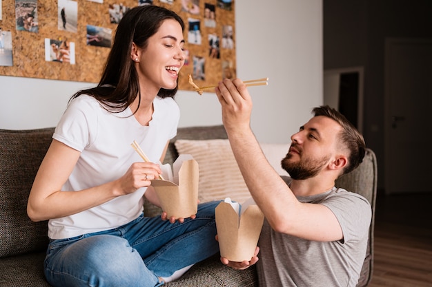 Sonriente hombre y mujer almorzando juntos en casa