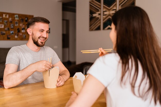 Sonriente hombre y mujer almorzando juntos en casa