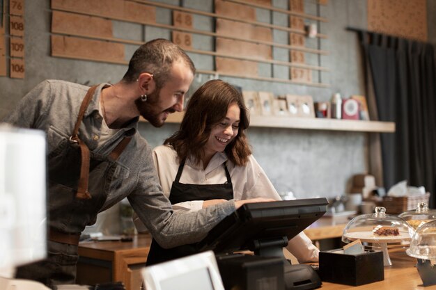 Sonriente hombre y mujer en caja registradora