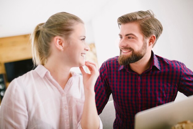 Sonriente hombre y mujer en la computadora portátil