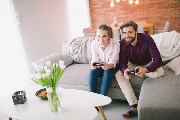 Sonriente hombre y mujer con gamepads