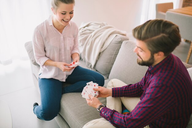 Sonriente hombre y mujer jugando a las cartas