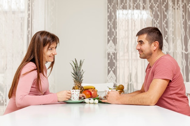 Sonriente hombre y mujer sirviendo té