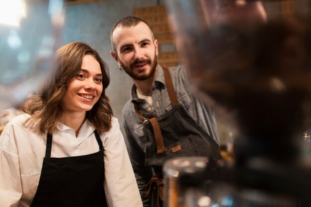 Sonriente hombre y mujer trabajando en cafetería