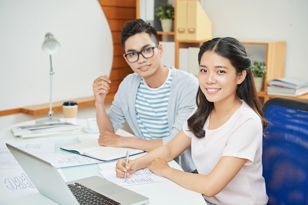 Sonriente hombre y mujer de trabajo en el escritorio