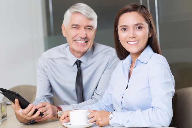 Sonriente hombre de negocios y compañera de trabajo en el Café