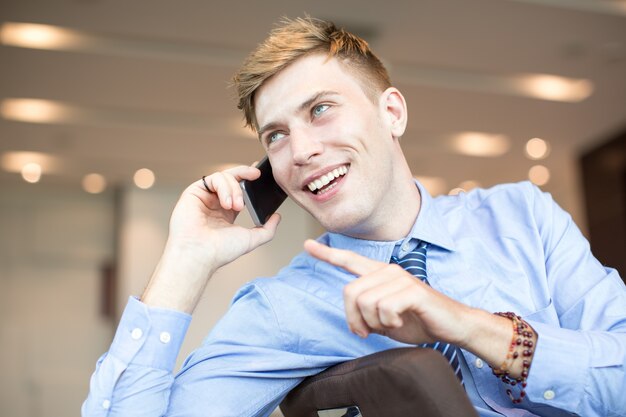 Sonriente hombre de negocios hablando por teléfono móvil