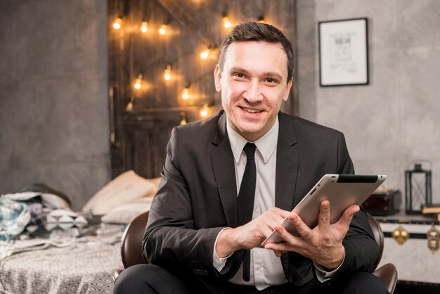 Sonriente hombre de negocios trabajando en tableta