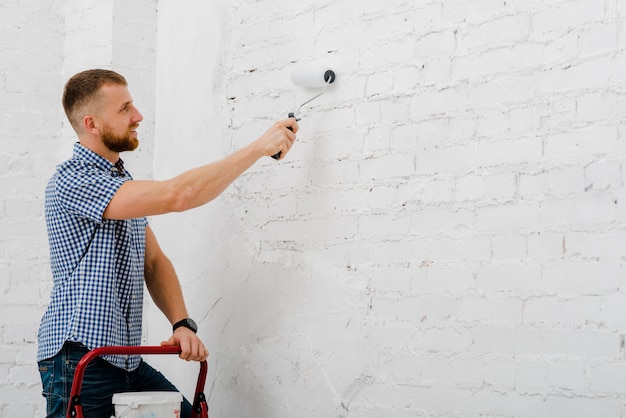 Sonriente hombre pintando la pared