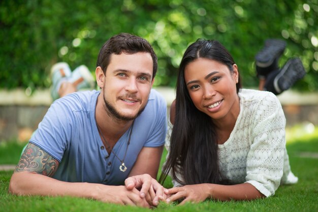 Sonriente, interracial, pareja, relajante, patio, pasto o césped