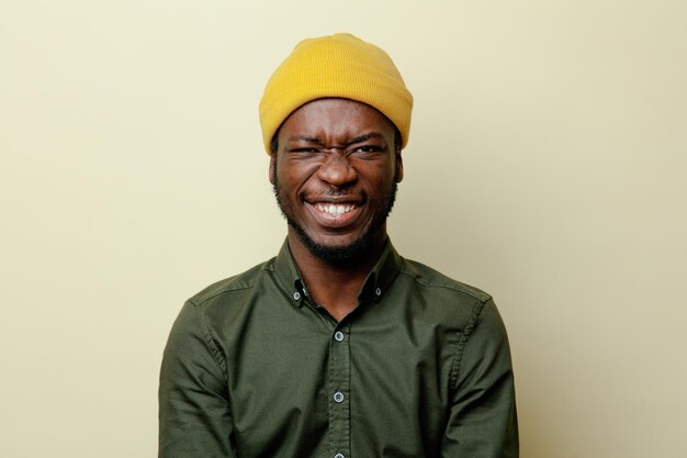 Sonriente joven afroamericano con sombrero con camisa verde aislado en fondo blanco 7