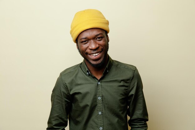 Sonriente joven afroamericano con sombrero con camisa verde aislado en fondo blanco