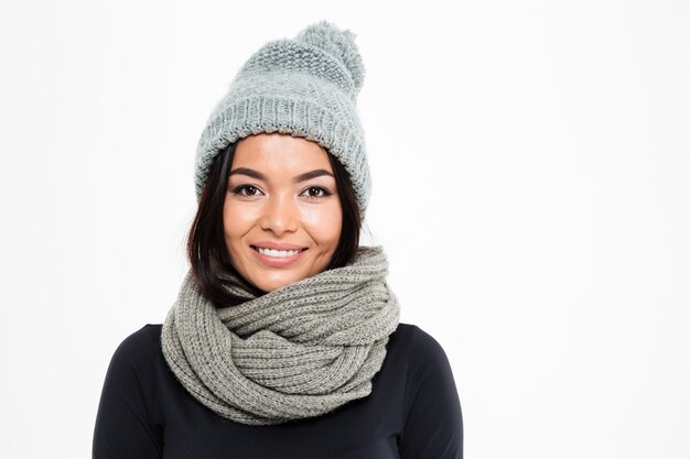 Sonriente joven asiática con gorro y bufanda