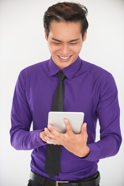 Sonriente joven asiático hombre de negocios usando tableta