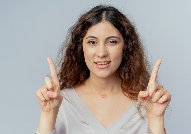 Foto gratuita sonriente joven bastante oficinista puntos en diferentes lados aislado en blanco