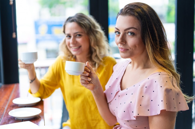 Sonriente a joven bebiendo café en café