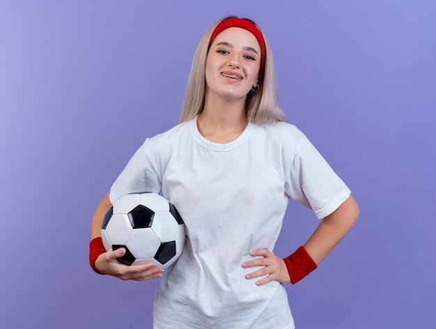 Foto gratuita sonriente joven caucásica deportiva con tirantes vistiendo diadema