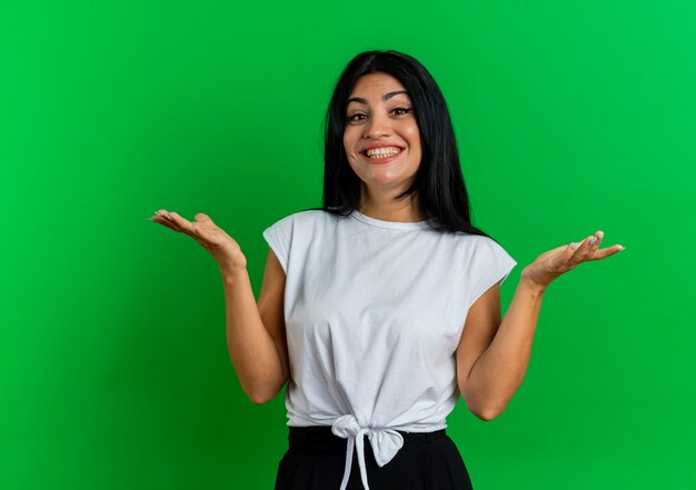 Sonriente joven caucásica mantiene las manos abiertas