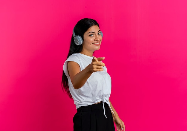 Sonriente joven caucásica en puntos de auriculares