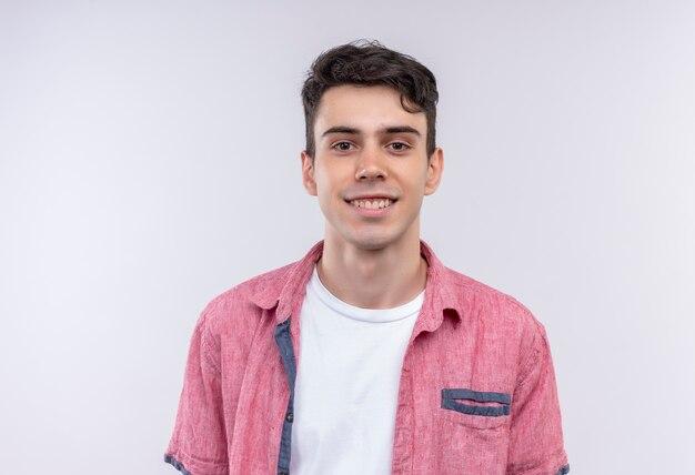 Sonriente joven caucásico vistiendo camiseta rosa sobre fondo blanco aislado