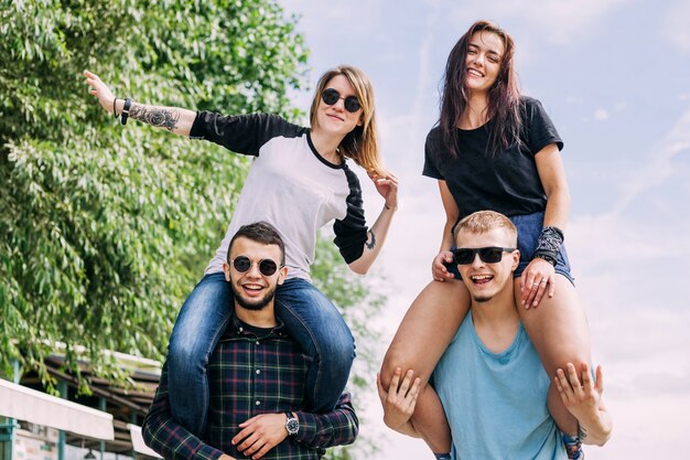 Sonriente joven disfrutando el paseo en el hombro del novio