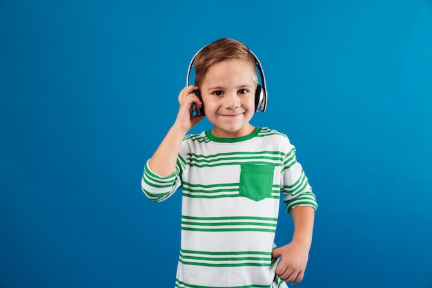 Sonriente joven escuchando música por auriculares