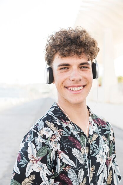 Sonriente joven escuchando música en auriculares